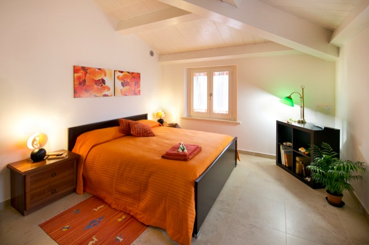 Camera mansardata accogliente con letto arancione